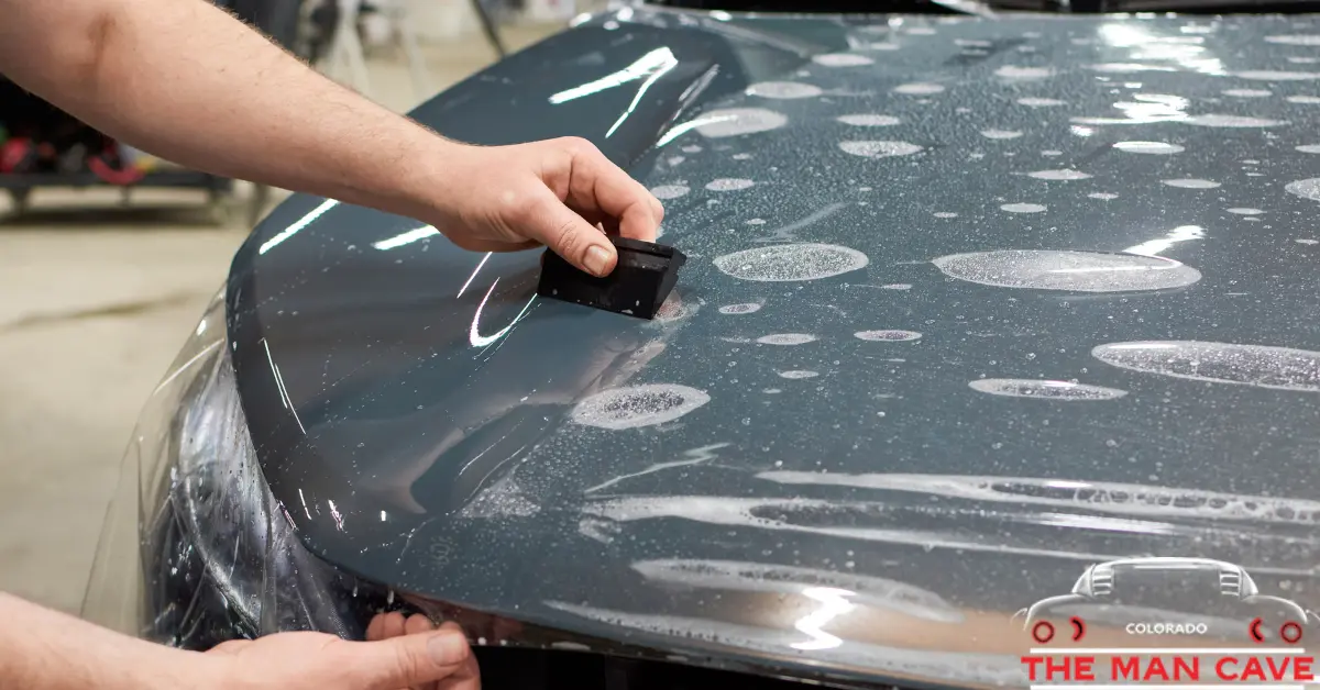 A Person applying paint protection film to car a hood. | MCC
