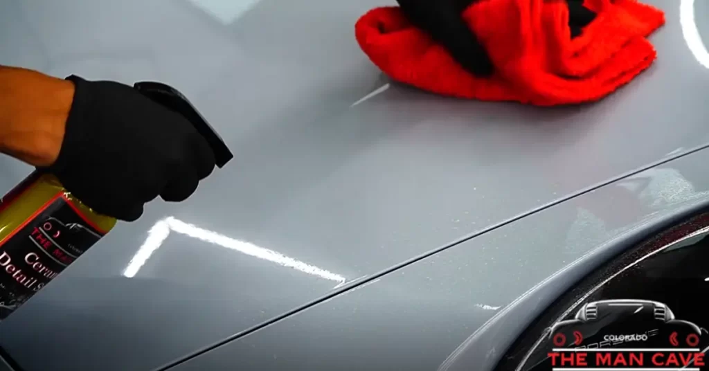 A person applying ceramic coating to a car hood at Man Cave Colorado