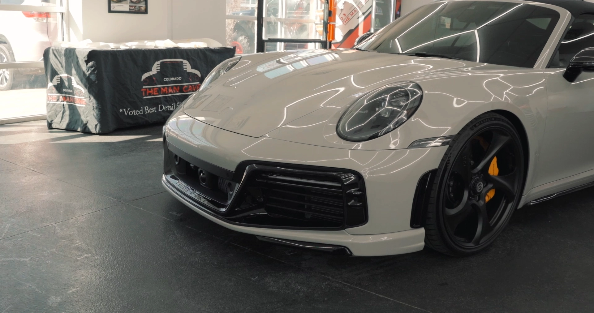 the front end of a porche 911 with ceramic coating applied to it at Man Cave Colorado