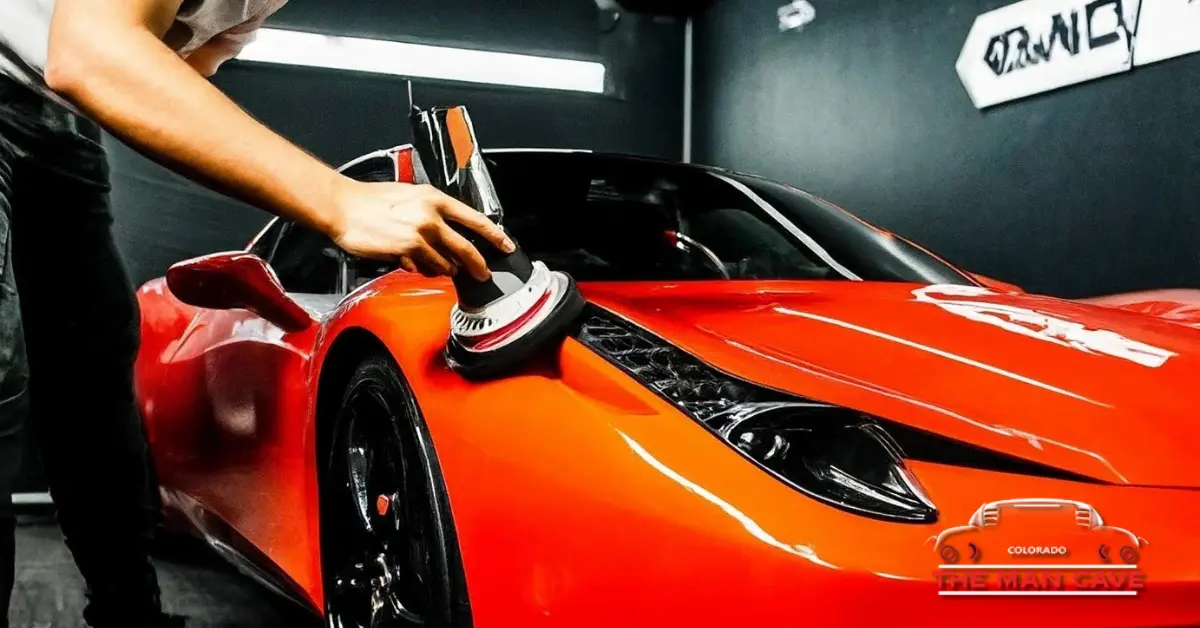 A man polishing a red sports car to make it shine