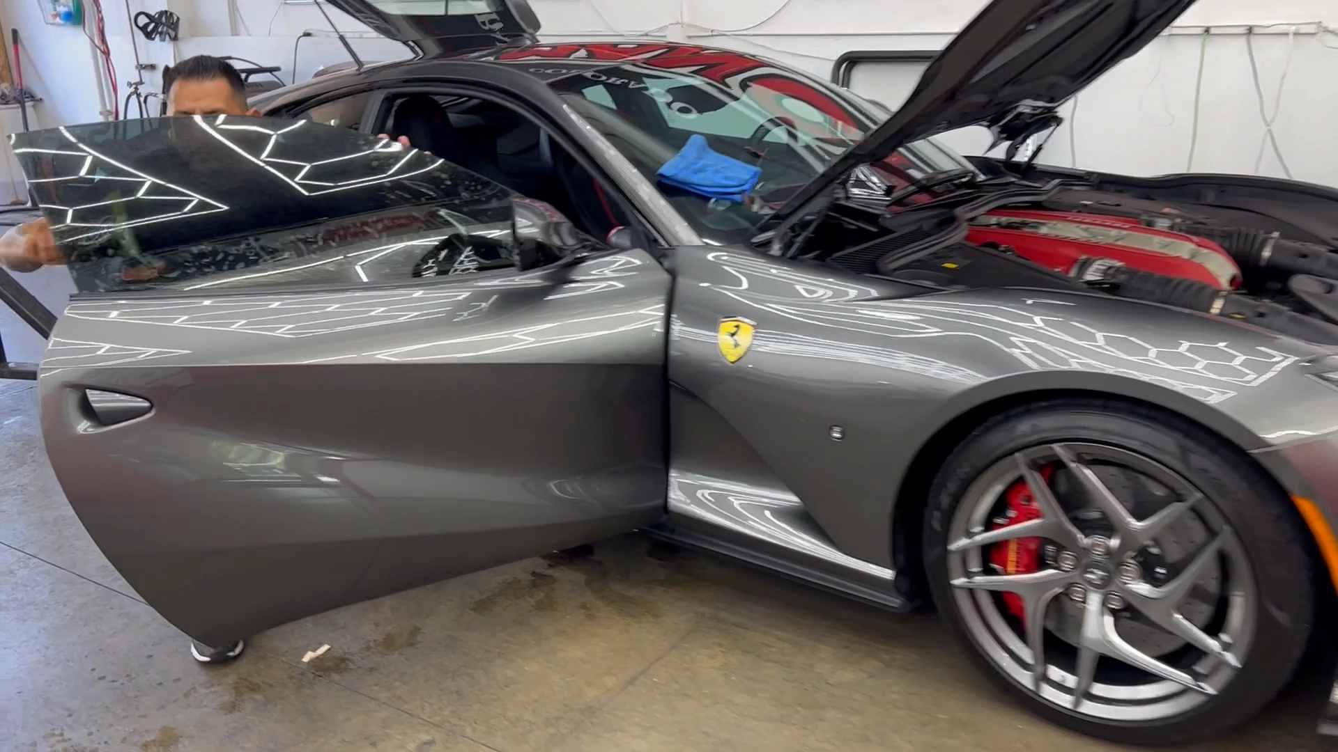 a man applying window tint to a Ferrari car door window at Man Cave Colorado